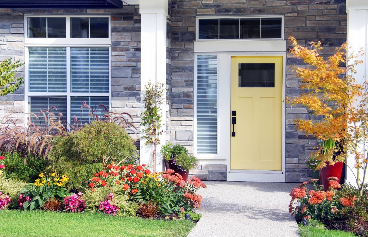 Suburban Front door painted with bright colors with planters on the front porch near Springfield, IL